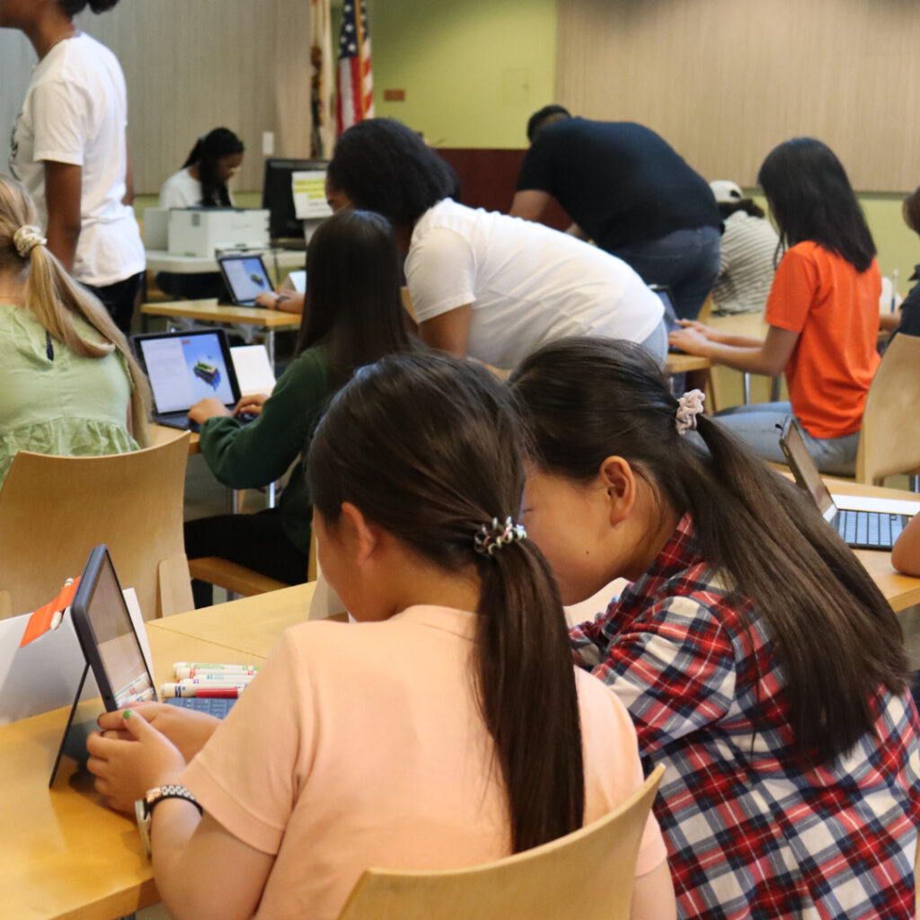 Girls practicing coding skills on their iPad.